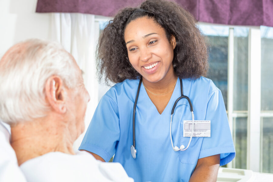 Nurse smiling at elderly patient in a hospital bed