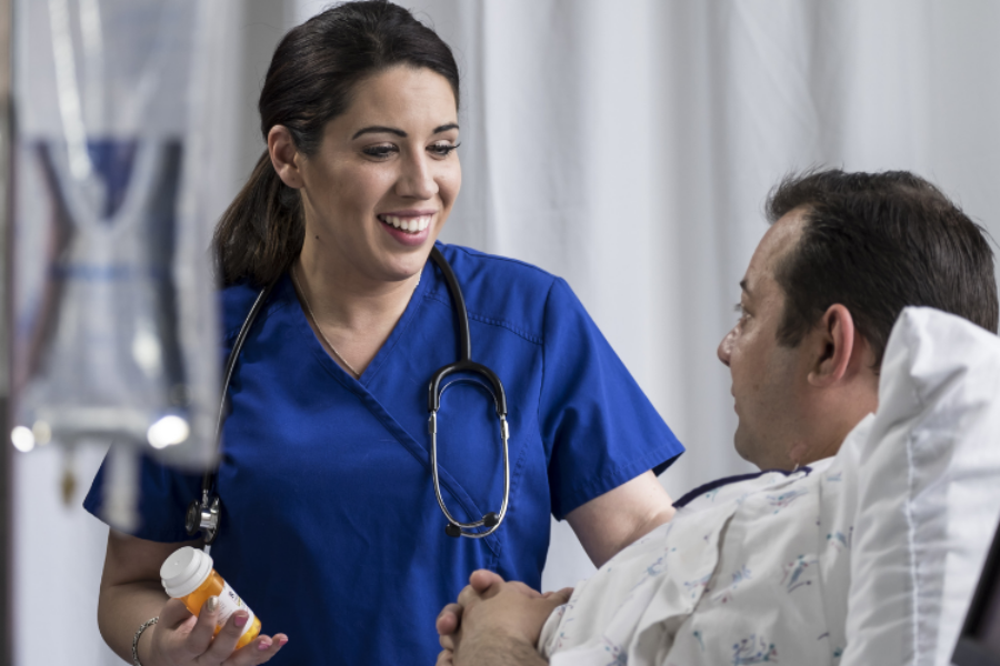 Nurse smiling at patient while giving the patient their medication